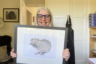 Jules Chabeaux holding her drawing of a beaver for the silent auction