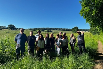 an image of 12 trustees on a sunny day stood in farmland