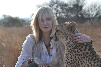 A woman sat with a cheetah