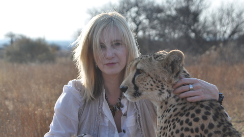 A woman sat with a cheetah