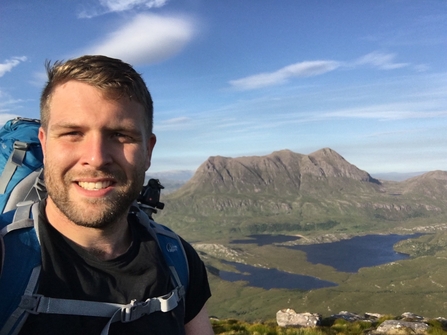 an image of a man hiking with wild landscape in the background