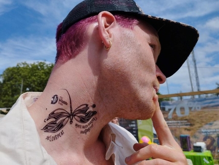 A photograph of a visitor to the Trust's stall at Glastonbury