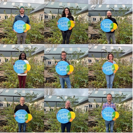 A collage of people holding the real living wage sign