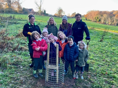 adults and children with tree planted at allestree park